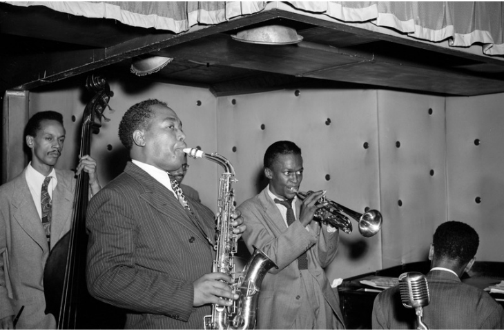 Van links naar rechts: Tommy Potter, Charlie Parker, Max Roach (achter Parker), Miles Davis en Duke Jordan, in de Three Deuces, New York, 1947, William P. Gottlieb (via Wikimedia Commons)